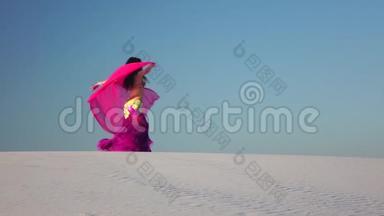 手里拿着面纱的女孩在沙漠里跳着肚皮舞。 慢动作